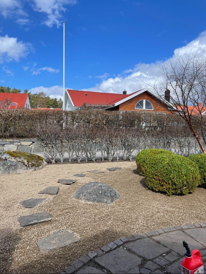 trädgårdsdesign i varberg En stengång i en grusad trädgård.