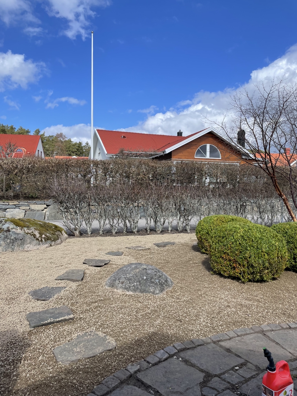 En stengång i en grusad trädgård.